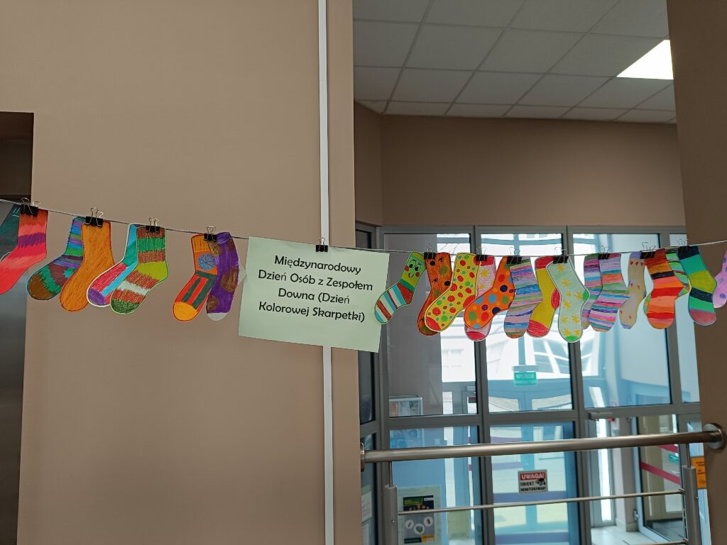 Zdjecie przedstawia kolorowe skarpetki zawieszone na sznurku